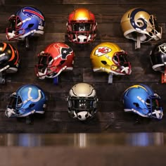 football helmets are lined up against a wooden wall