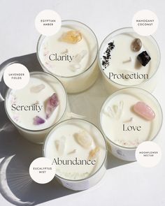 four candles with different types of crystals in them on a white surface, surrounded by the names of each candle