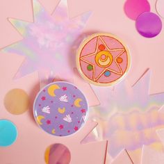 two badges sitting next to each other on top of a pink table covered in confetti