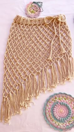 a crocheted shawl and doily on a white tablecloth with other items