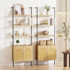 a living room with shelves and plants on the wall next to a table in front of a potted plant