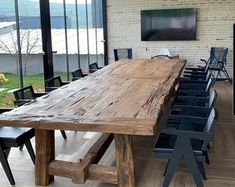 a large wooden table sitting inside of a room next to a tv on top of a hard wood floor