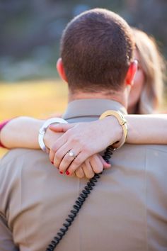 a man and woman embracing each other with their hands on the back of his shoulder