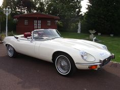 a white sports car parked in front of a house