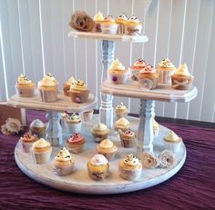 three tiered tray with cupcakes on top of it and other pastries