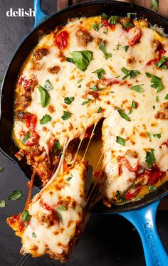 a skillet filled with cheese and meat covered in sauce