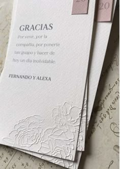 some white cards that are laying on top of each other with writing in spanish and english