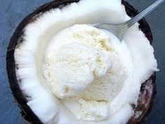 a scoop of ice cream in a coconut shell with a spoon sticking out of it