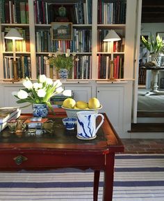 a table with some lemons on it in front of a book shelf filled with books