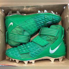 a pair of green nike football cleats in a box