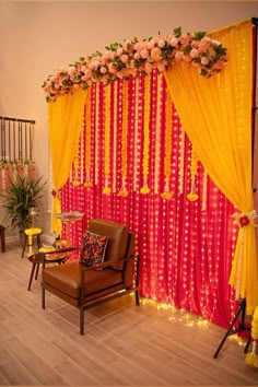 a chair sitting in front of a red and yellow drape with flowers on it