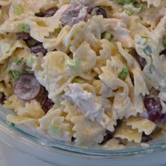 a pasta salad with grapes and celery in a glass bowl