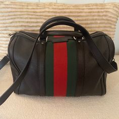 Classic Gucci Boston Bag Crafted In Black Grained Leather, Featuring Signature Green And Red Striped Web Canvas Paneling, Finished With Pale Gold-Tone Hardware. In Addition To Two Rolled Leather Top Handles, The Bag Includes A Detachable Leather Shoulder Strap For Versatile Carry. Gucci Black Shoulder Bag For Business, Gucci Black Leather Shoulder Bag, Black Gucci Leather Shoulder Bag, Black Leather Gucci Shoulder Bag, Gucci Black Crossbody Shoulder Bag, Black Gucci Crossbody Shoulder Bag, Gucci Leather Lined Shopping Bag, Gucci Leather Top Handle Bag, Gucci Satchel With Leather Handles