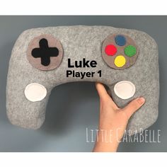 a hand is holding a game controller pillow