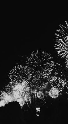 black and white photograph of fireworks in the night sky