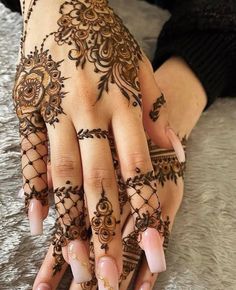 a woman's hand with henna tattoos on it