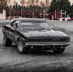 a black muscle car parked in a parking lot