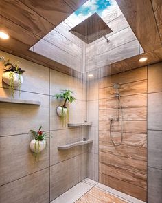 a bathroom with wooden walls and flooring has a skylight above the shower head