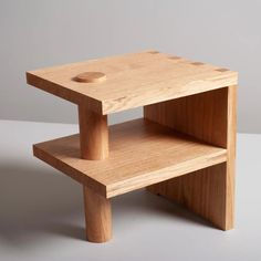 two wooden tables stacked on top of each other, one with a hole in the middle