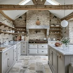 an old fashioned kitchen with stone floors and exposed beams, white appliances and gray cabinets