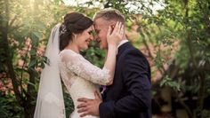 a bride and groom embracing each other in front of trees