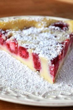 a piece of pie on a plate covered in powdered sugar