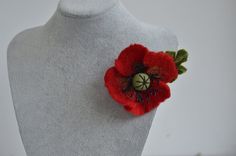 a close up of a red flower on a mannequin's neck piece