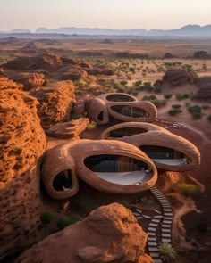 an aerial view of the desert with rocks and stairs leading up to two round shaped buildings