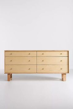 a wooden dresser sitting on top of a white floor