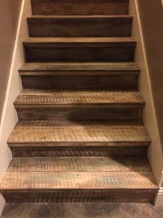 a set of wooden steps leading up to the top of a stair case in a home