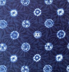 a blue and white tie - dyed fabric with circular design on the top, as well as small circles