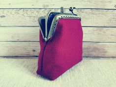 a small red purse with silver zippers on it sitting on top of a table