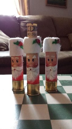 three wine bottles decorated like santa claus on a checkered table