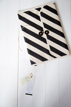 a black and white striped bag sitting on top of a table next to a tag