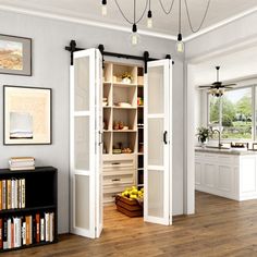 an open pantry in the middle of a room with wooden floors and white walls, along with bookshelves