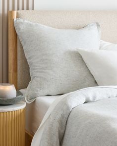 a close up of a bed with white pillows