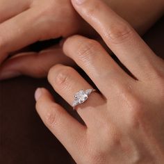 a woman's hand with a diamond ring on it