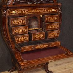 an old fashioned wooden desk with drawers on the top and bottom shelf, inlaided with floral designs