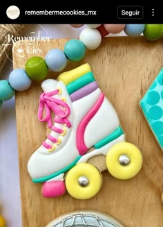 a decorated cookie with roller skates and beads on a wooden board next to other decorations