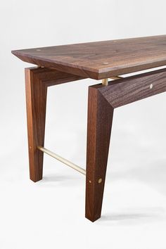 a wooden table with a metal bar underneath it