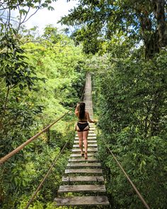 a woman is walking down the stairs in the forest