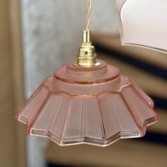 a pink light fixture hanging from a ceiling