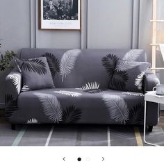 a gray couch with palm leaves on it