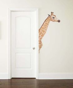 a giraffe standing in front of an open door