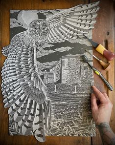 a person is drawing an owl on a piece of paper