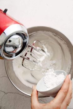 a hand mixer mixing white powder in a bowl