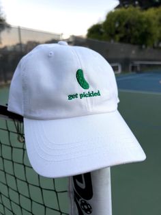 "The perfect gift for a pickle ball champ or any pickle lover.  * 100% chino cotton twill * Unstructured, 6-panel, low-profile * 6 embroidered eyelets * 3 ⅛\" (7.6 cm) crown * Adjustable strap with antique buckle This product is made especially for you as soon as you place an order, which is why it takes us a bit longer to deliver it to you.  RETURNS AND EXCHANGES * All sales are final unless the item arrives damaged * If your item arrives damaged, please contact us within 28 days of receiving Cotton Dad Hat With Letter Embroidery For Baseball Season, Novelty Cotton Baseball Cap One Size, Novelty Cotton Baseball Cap One Size Fits Most, Novelty Cotton Adjustable Baseball Cap, White Cotton Dad Hat With Letter Embroidery, Novelty Cotton Baseball Cap, Custom Embroidered Cotton Dad Hat, Adjustable Cotton Dad Hat With Custom Embroidery, Novelty Cotton Snapback Baseball Cap