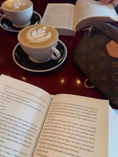 an open book sitting on top of a table next to a cup of coffee