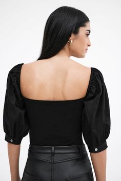 Our Alana Top is an ode to love. A day-to-night romantic look, her fitted bodice in high-stretch and sustainable European jersey features a square neck that gracefully frames your face and neck, while billowy mid-length sleeves in European poplin cotton are punctuated by mother-of-pearl button cuffs for a poetic finish. Sister to our Shira Top Alana's double-layered for comfort and support.[SPLIT] Sam, in black, is 5'8" (173 cm) tall, wearing size XS. Shannon, in off white, is 5'8" (173 cm) tall Elegant Square Neck Top In Elastane, Elegant Square Neck Elastane Top, Elegant Square Neck Top With Gathered Sleeves, Elegant Ruched Puff Sleeve Top, Fitted Square Neck Top With Gathered Neckline, Fitted Puff Sleeve Top For Evening, Fall Square Neck Puff Sleeve Top, Fitted Tops With Gathered Square Neckline, Chic Puff Sleeve Top With Square Neck For Fall