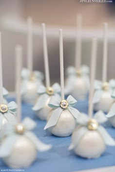 there are many small white balls with bows on them and some candles in the middle